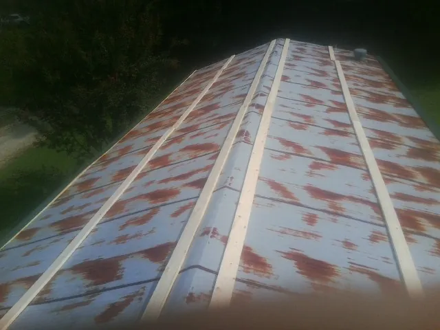 Rusted metal roof panels with new wood purlins before replacement — Storm Damage Roof Repair in Anthon by Roofing Brothers