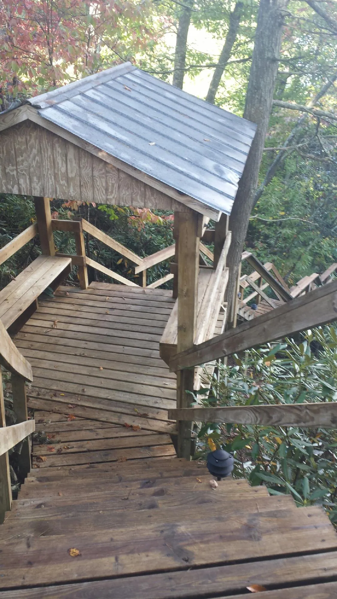 Metal roofed shelter over wooden steps on a wooded walkway — Skylight Repair & Installation work by our crew in Anthon