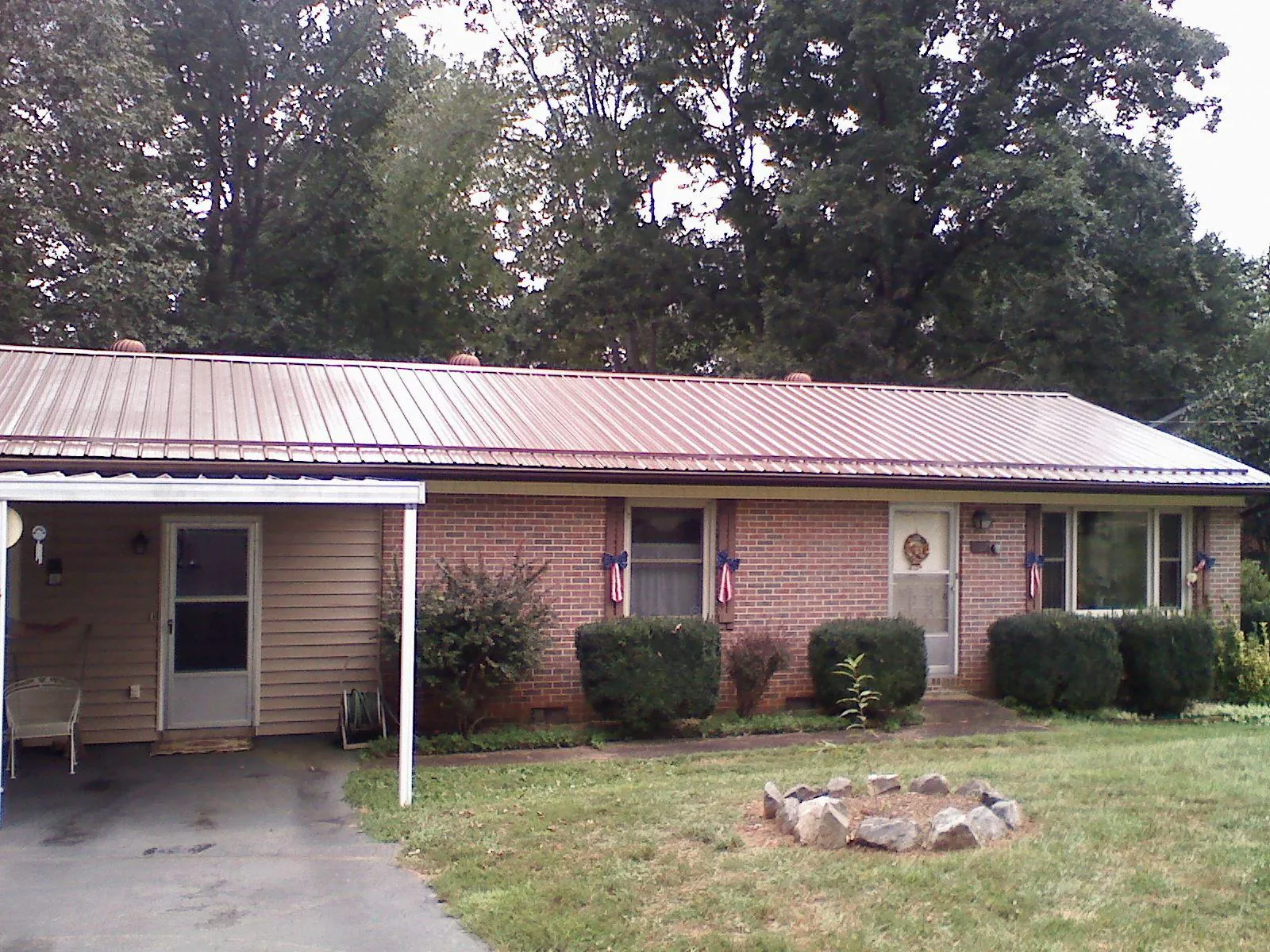 Bronze metal roof and carport on a brick ranch home — Roof Repair work by our crew in Anthon